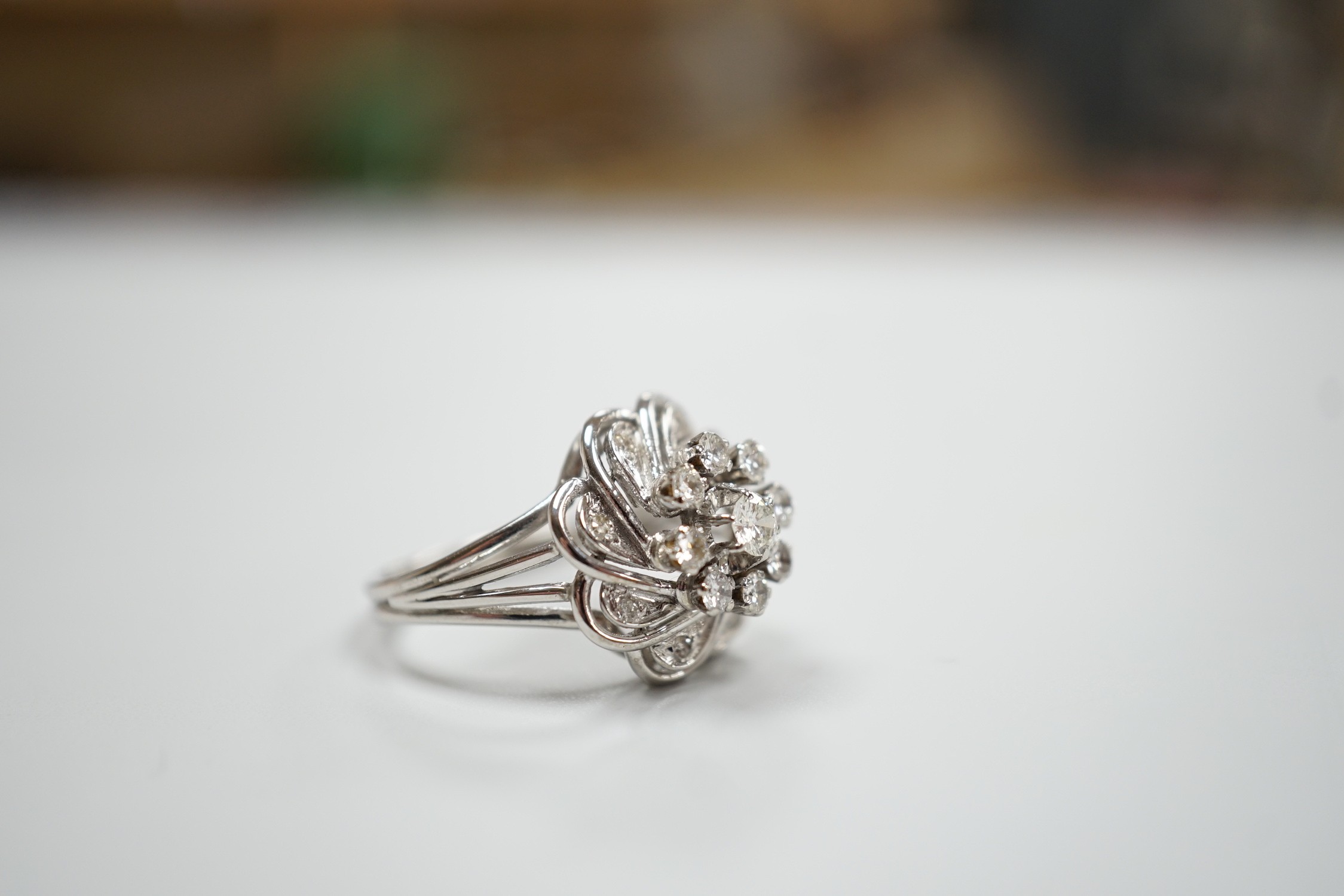 A French white metal (18ct poincon mark) and diamond cluster set dress ring, size L/M, gross weight4.8 grams.